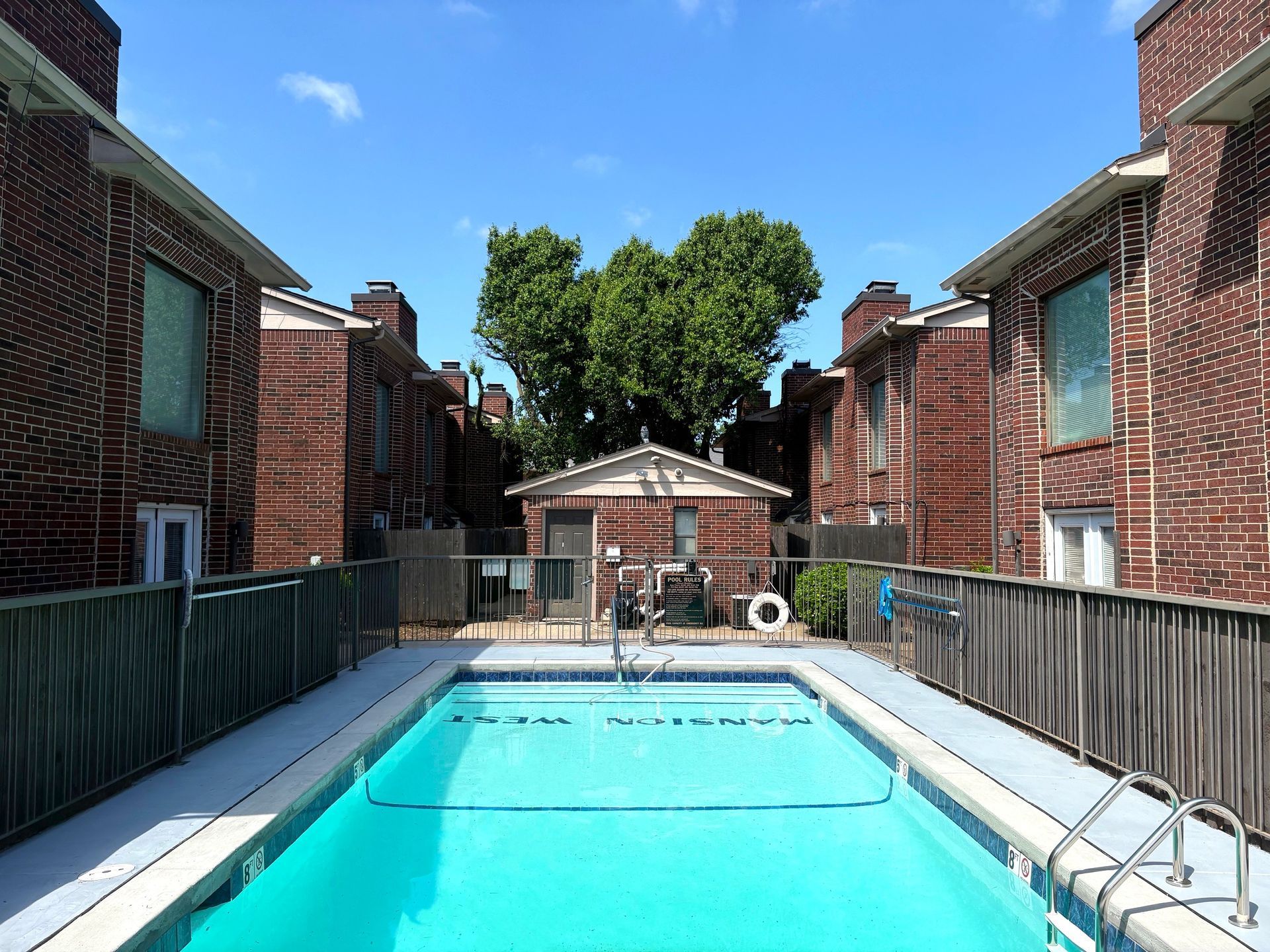 Swimming pool with lounge chairs and a building in the background.