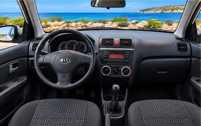 Dashboard van een witte Kia Picanto huurauto