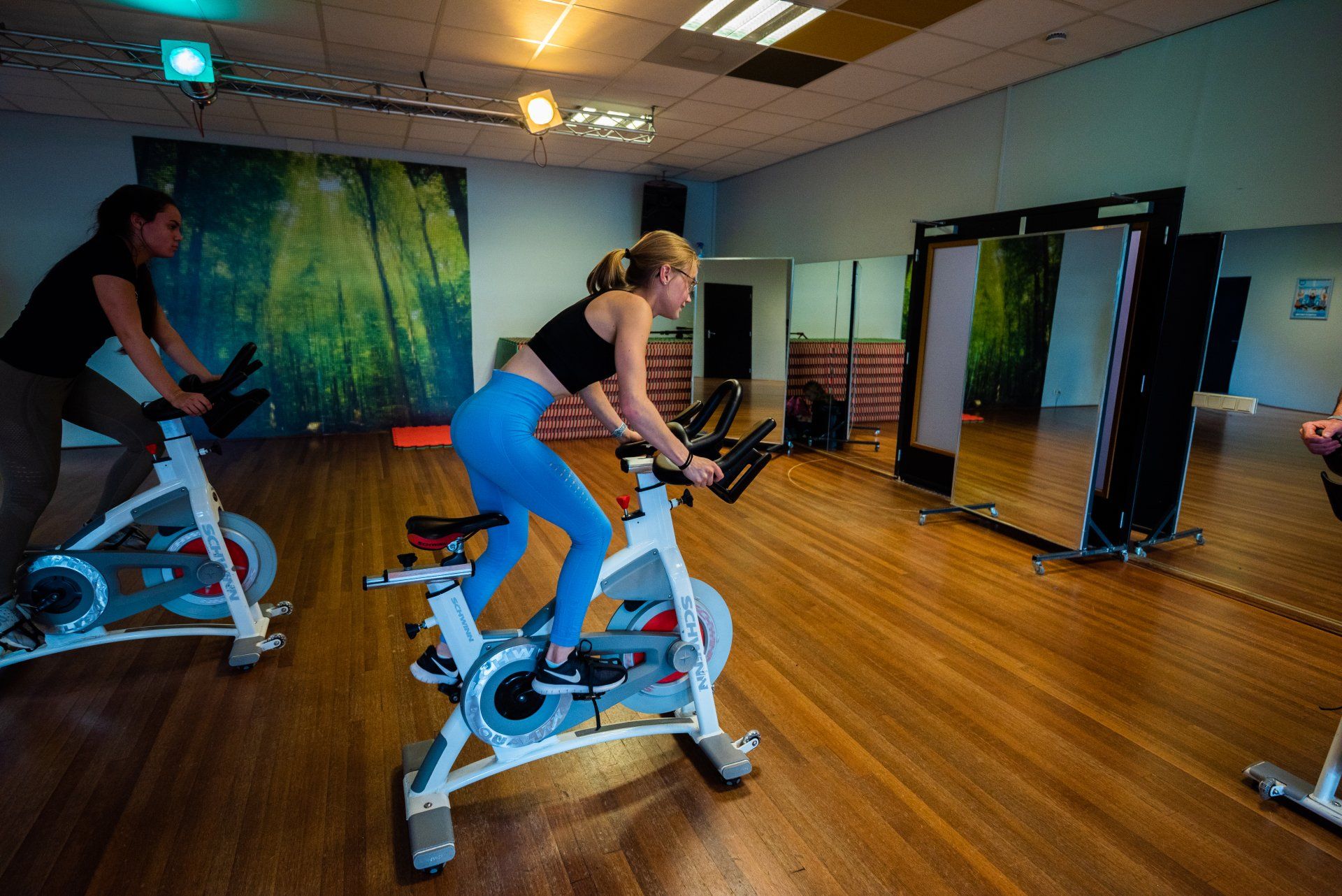 Een vrouw rijdt op een hometrainer in een sportschool.