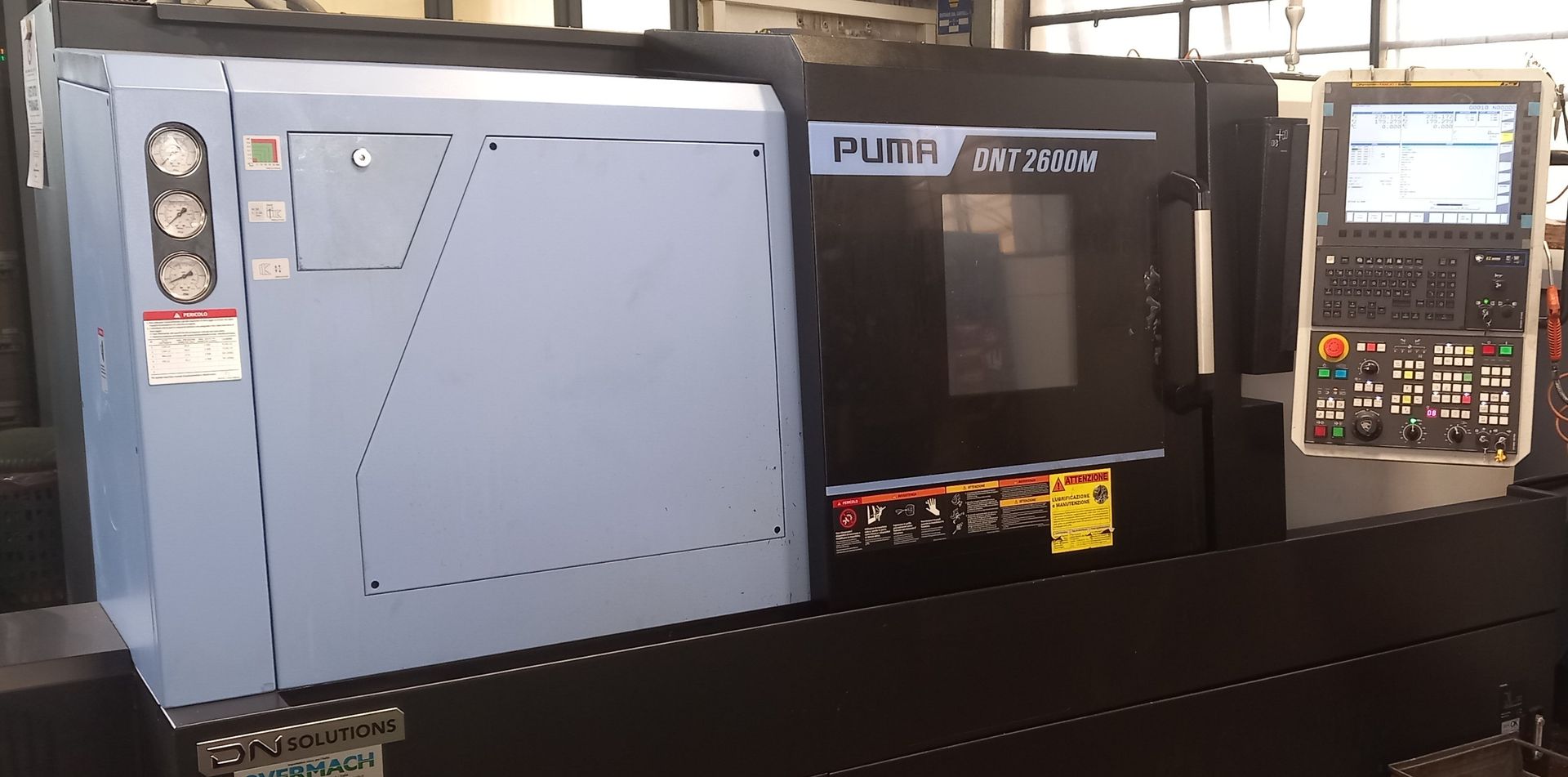 Pannello di controllo per macchinari industriali con armadio blu, unità centrale nera e display digitale a destra.