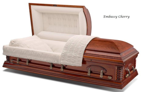 Open cherry wood casket with white interior and white blanket