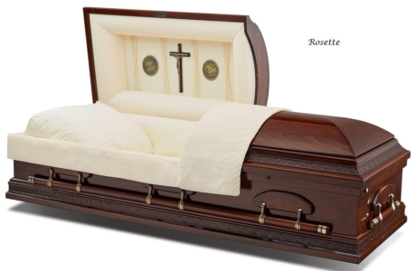 Open casket with cream lining and dark wood finish with brass handles