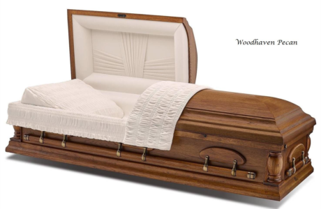 Wooden casket with white satin lining and floral detailing on a white background