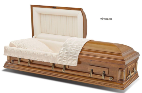Wooden casket with white satin lining and floral accents, shown open at the head end.