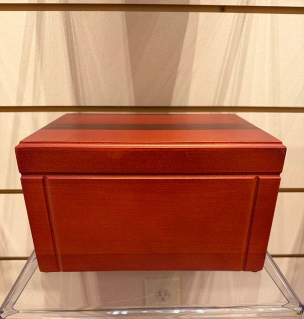 Red wooden storage box with hinged lid on a clear display stand
