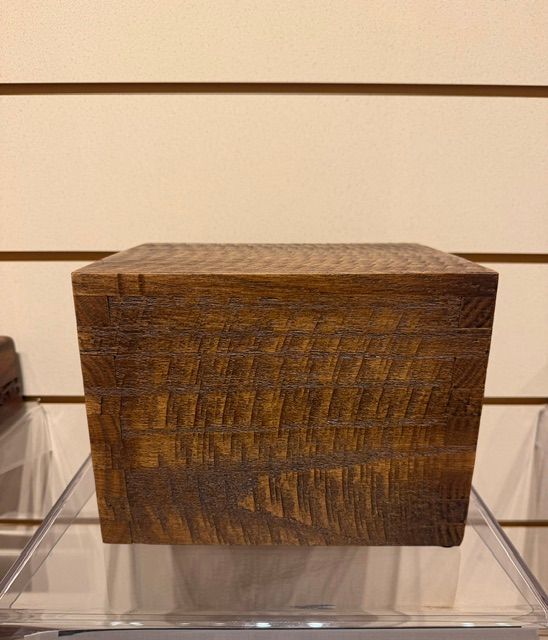 Small rectangular woven wooden box with a lid, displayed on a clear stand.