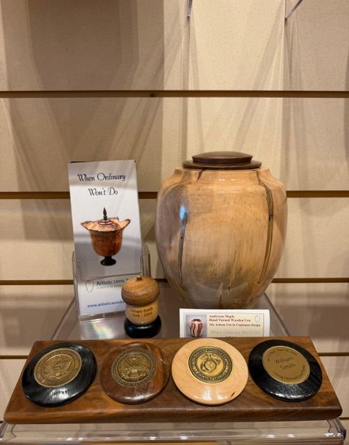 Display shelf with a large tan jar, small containers, and round labeled tins on a wooden base.