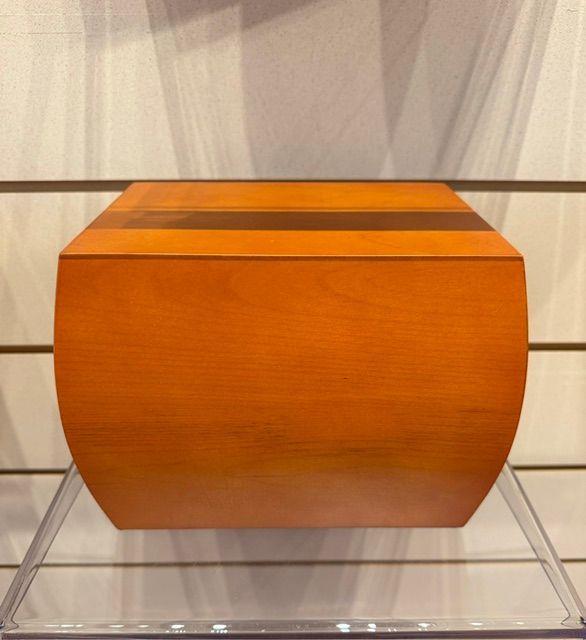 Orange wooden chest with curved sides, displayed on a clear stand against a light background