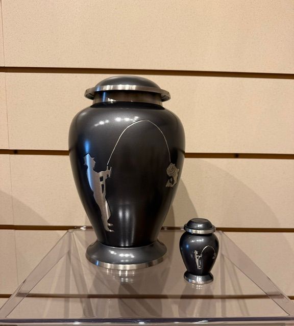 Two glossy black urns, one large and one small, displayed on clear shelves against a beige wall.