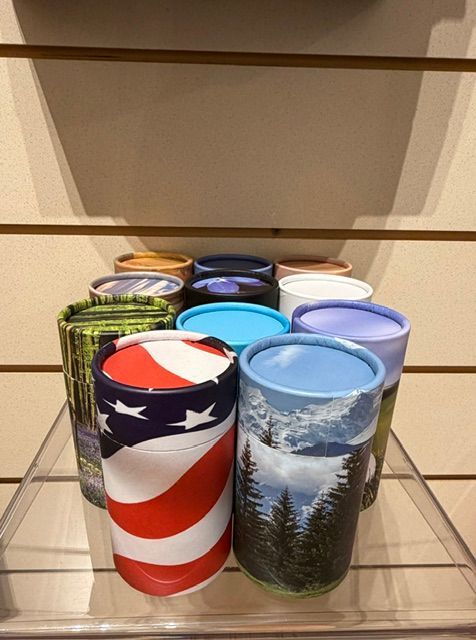 Assorted patriotic tumblers displayed on a glass shelf, including red, white, and blue American flag designs.
