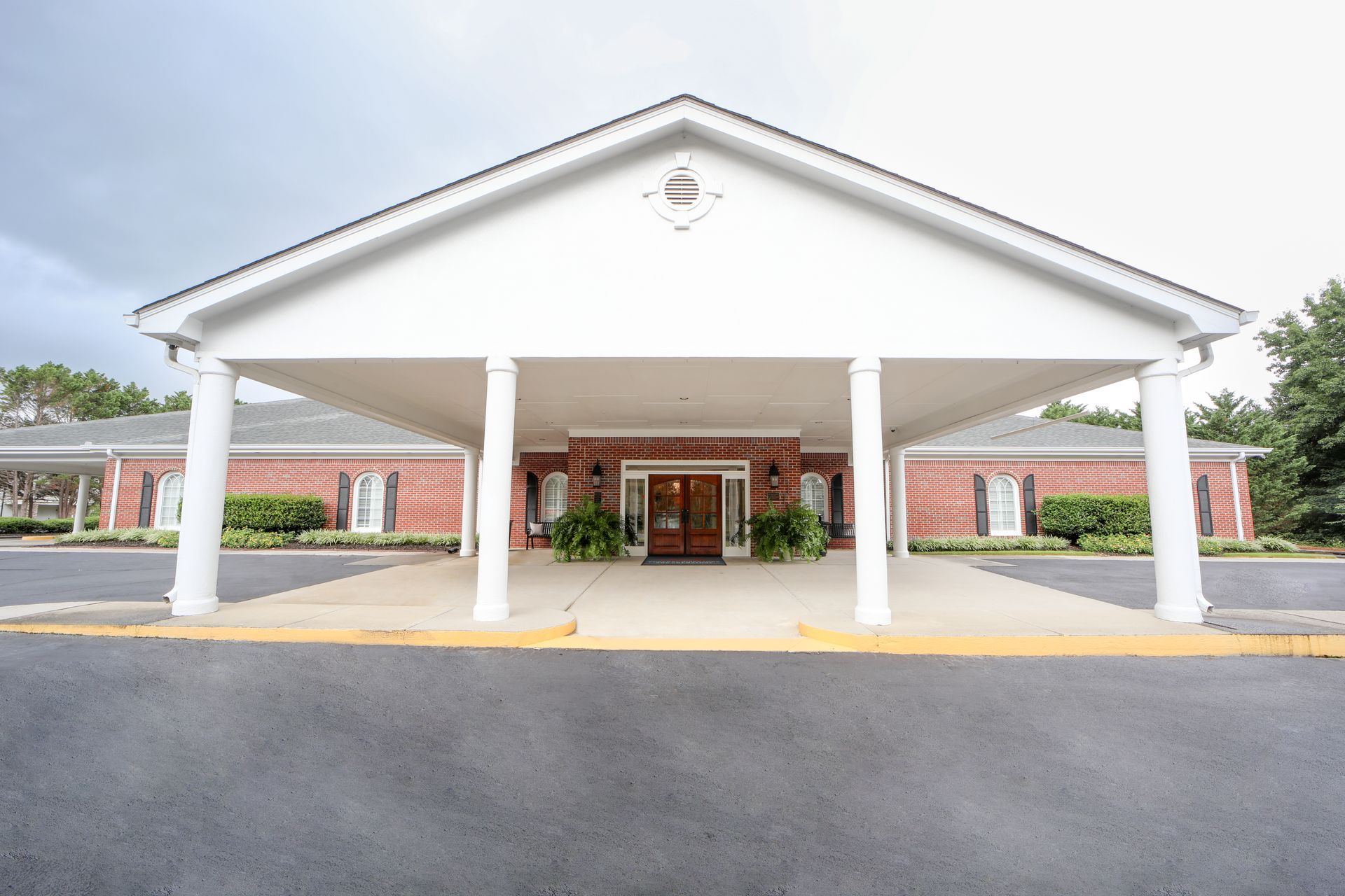 Covered entrance of a white building with columns and a central doorway