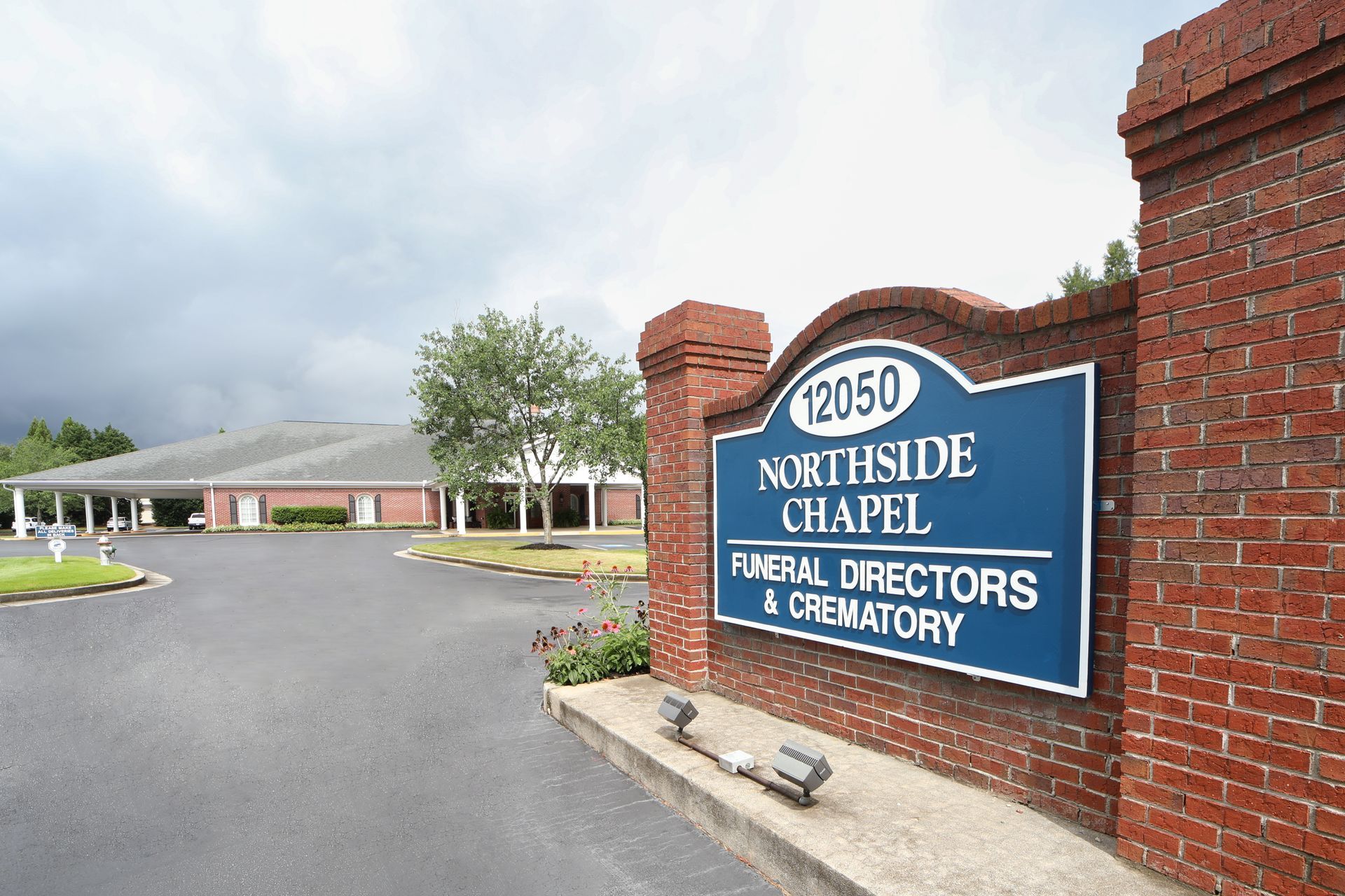 Northside Chapel Funeral Directors & Crematory entrance sign beside brick building and driveway