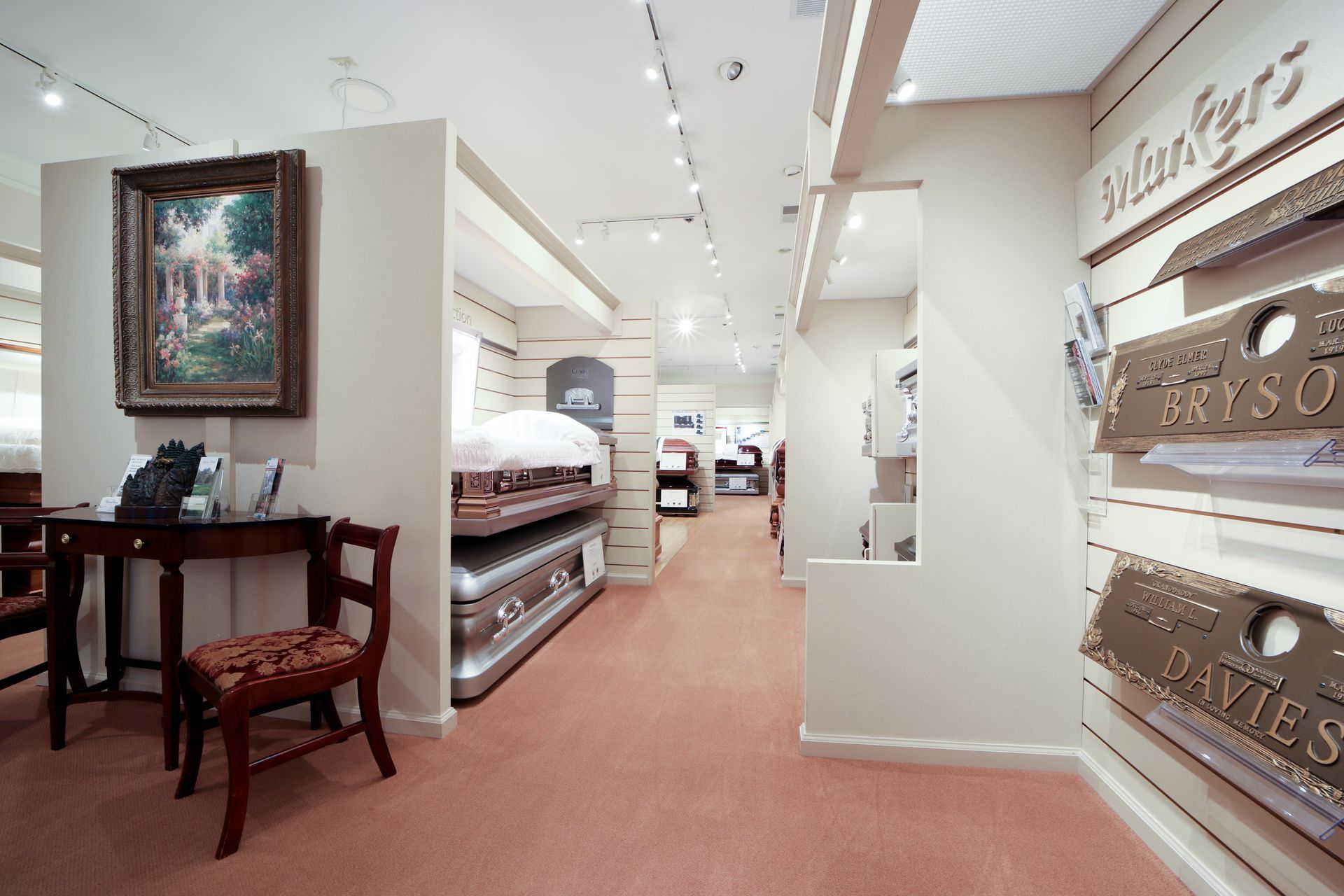Bright showroom interior with shelves of folded linens and a small wooden table on the left.