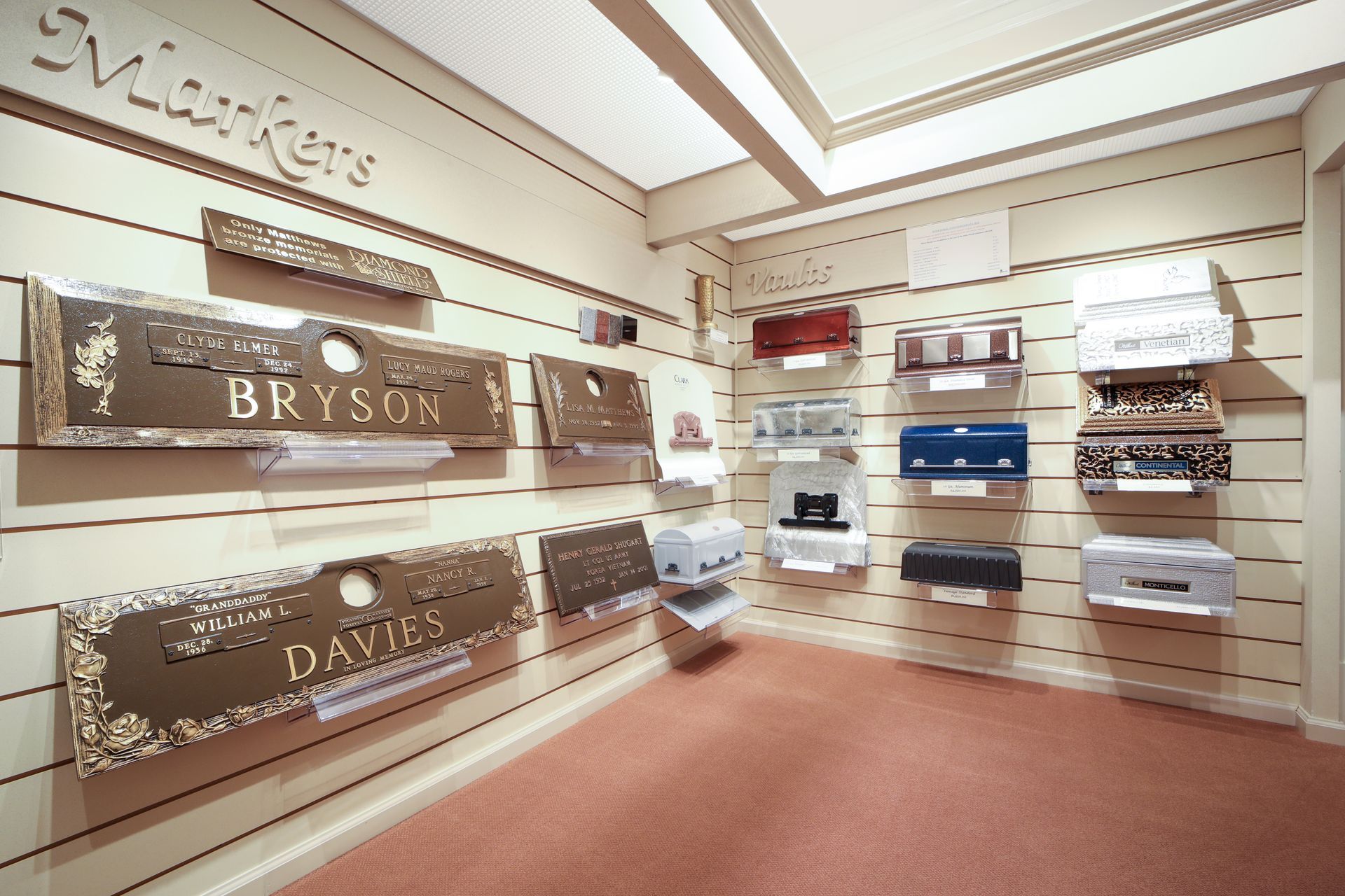 Boutique showroom with wood-paneled walls, shelves of folded textiles, and carpeted floor