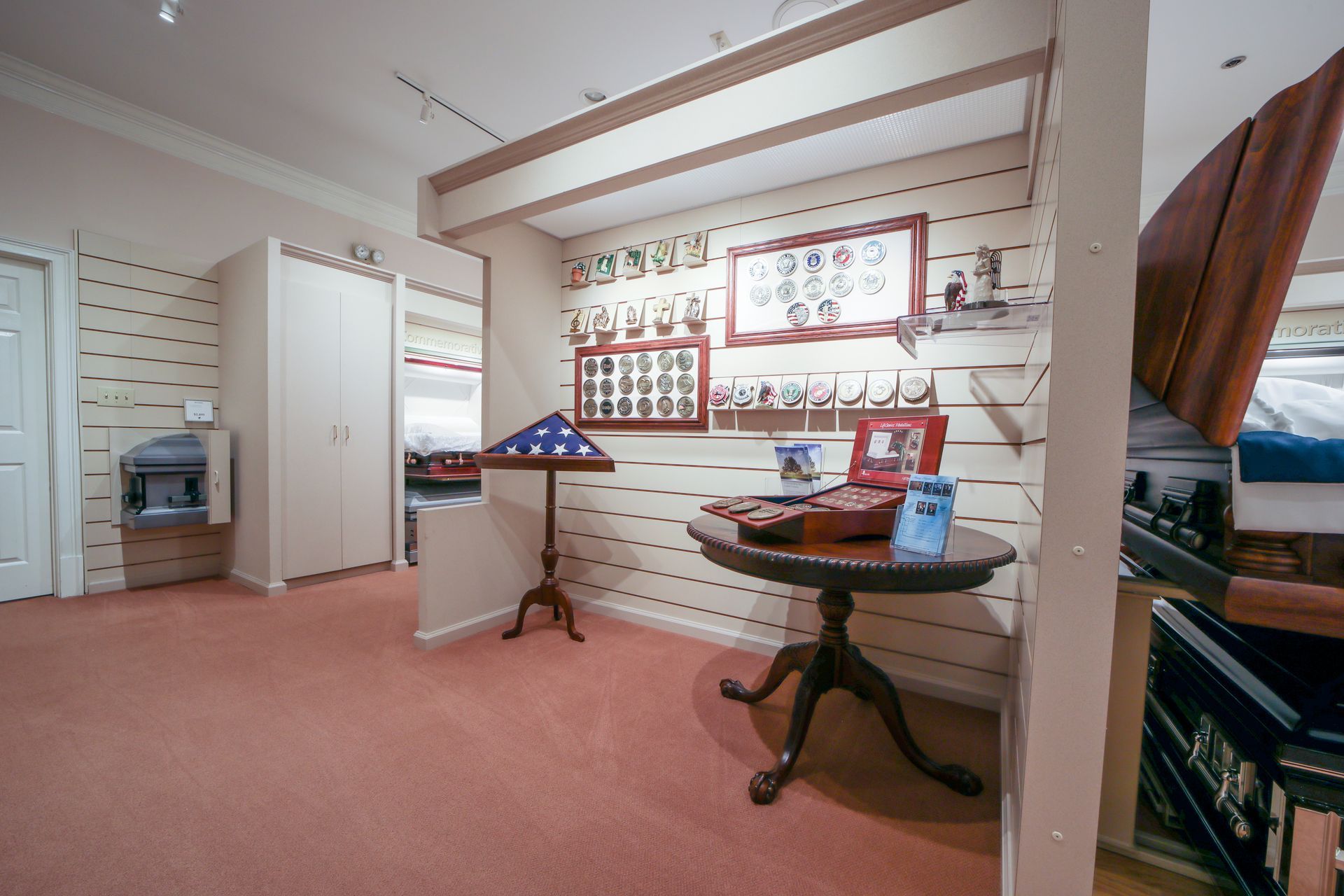 Bright room with carpet, display boards, a small table, and a podium near a doorway