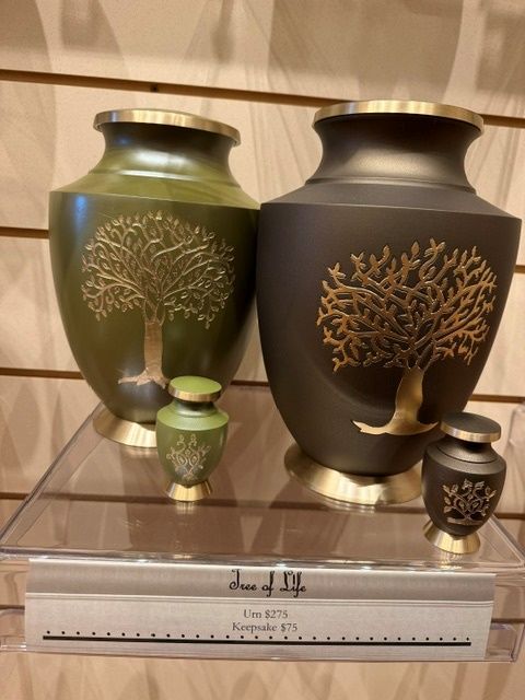 Two decorative urns with gold tree designs and two small matching vases on a shelf, with a ruler below