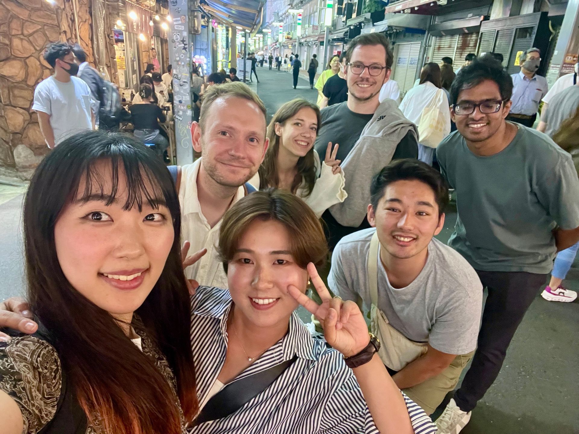 The Sunrise Adventure team smiling together in a lantern lit Tokyo street at night