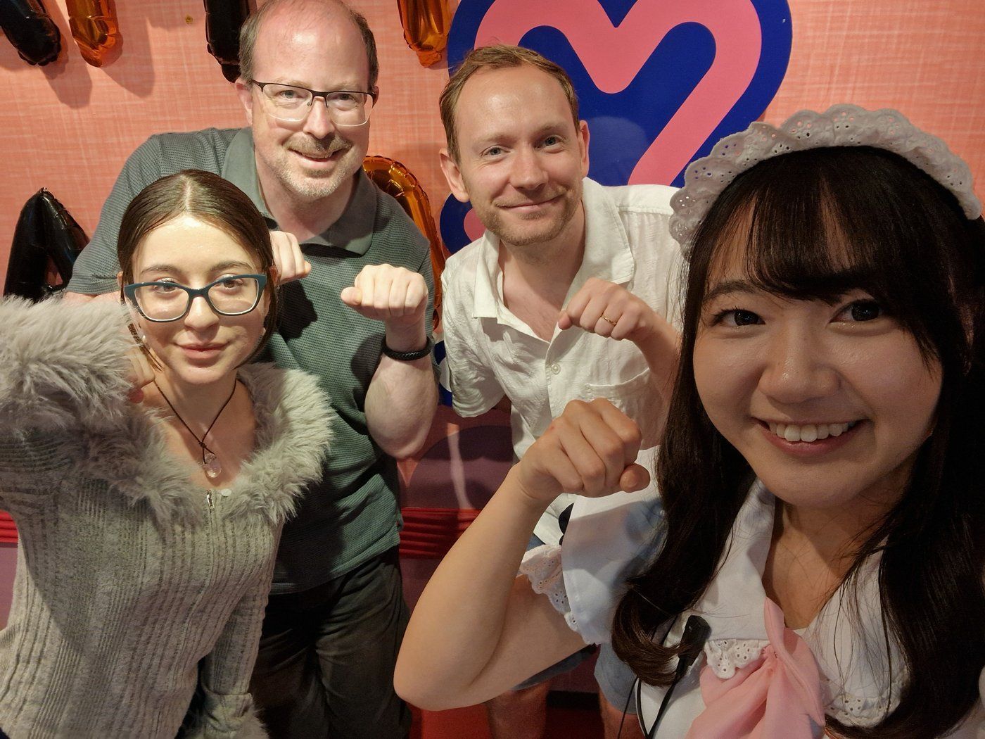 Four people posing together in an Akihabara maid cafe