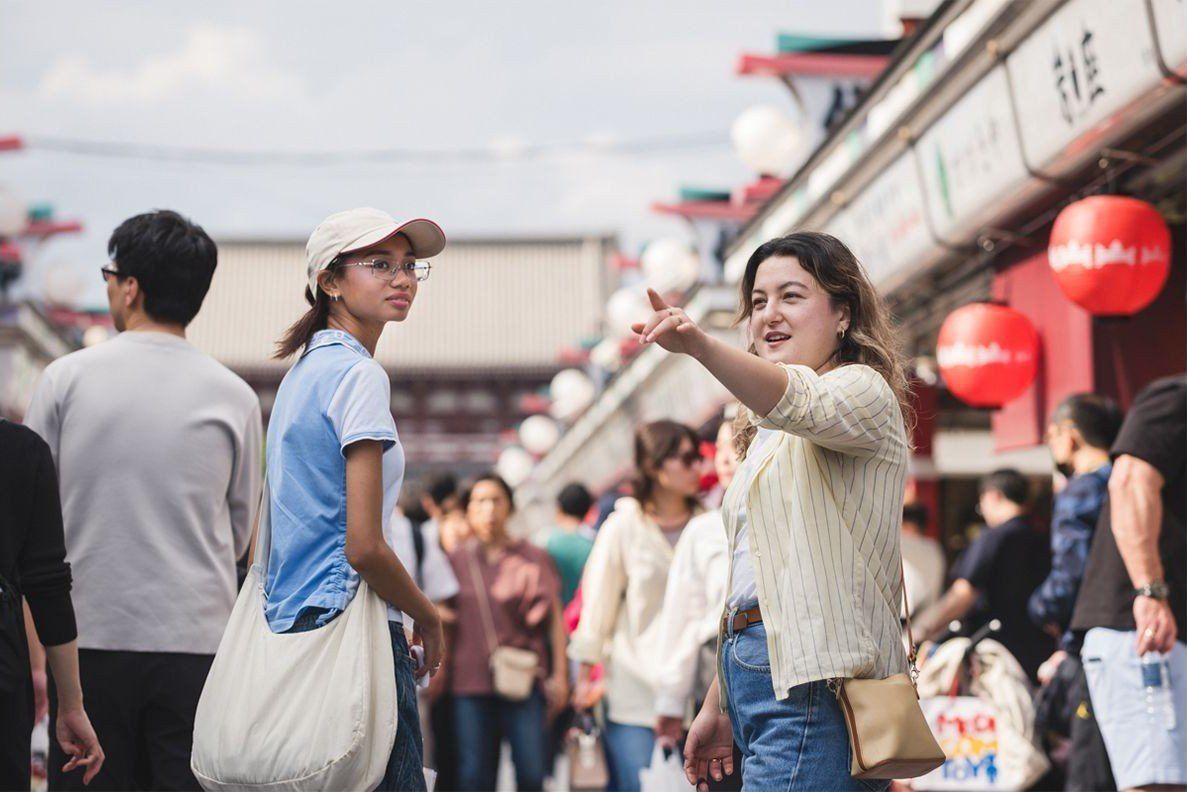 A guide pointing out the way to a guest on Nakamise street in Asakusa