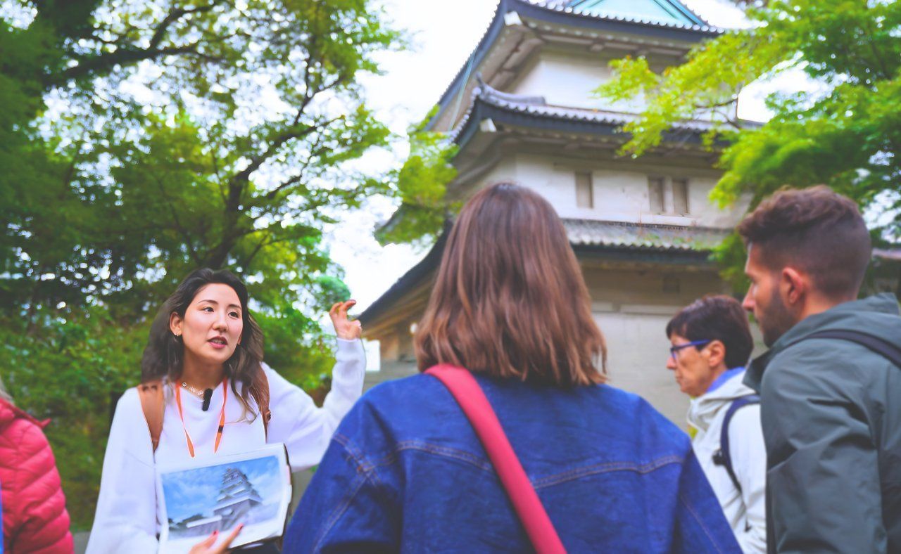 A guide explaining history to a small group near the Imperial Palace