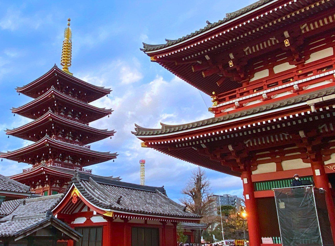 Five story pagoda and red temple halls in Asakusa under a blue sky