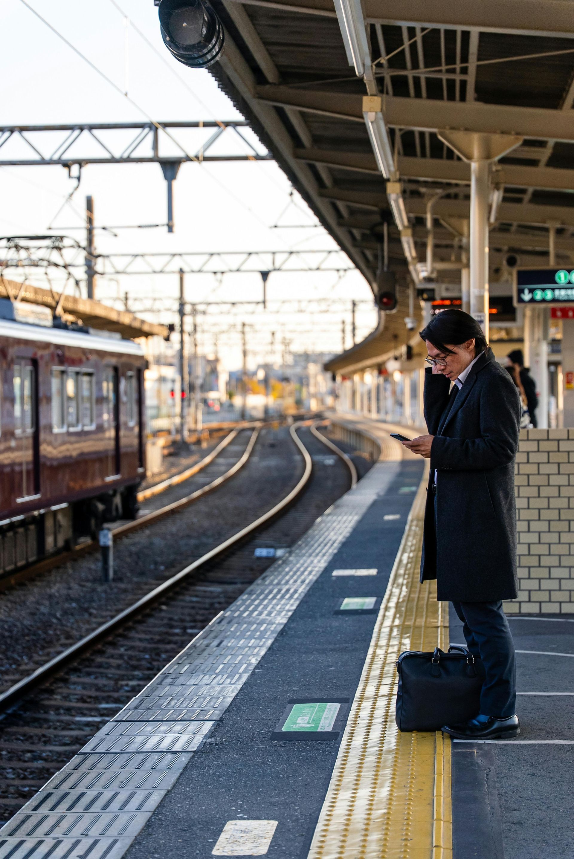 Tokyo train station platform with overhead rail tracks and canopy