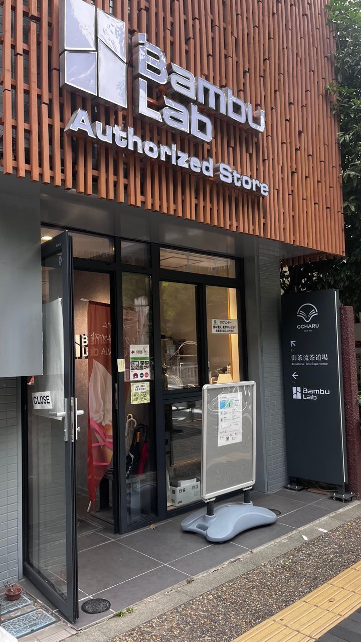 The outside of the building: the ground-floor Bambu Lab store, and the black OCHARU sign pointing to the tea room