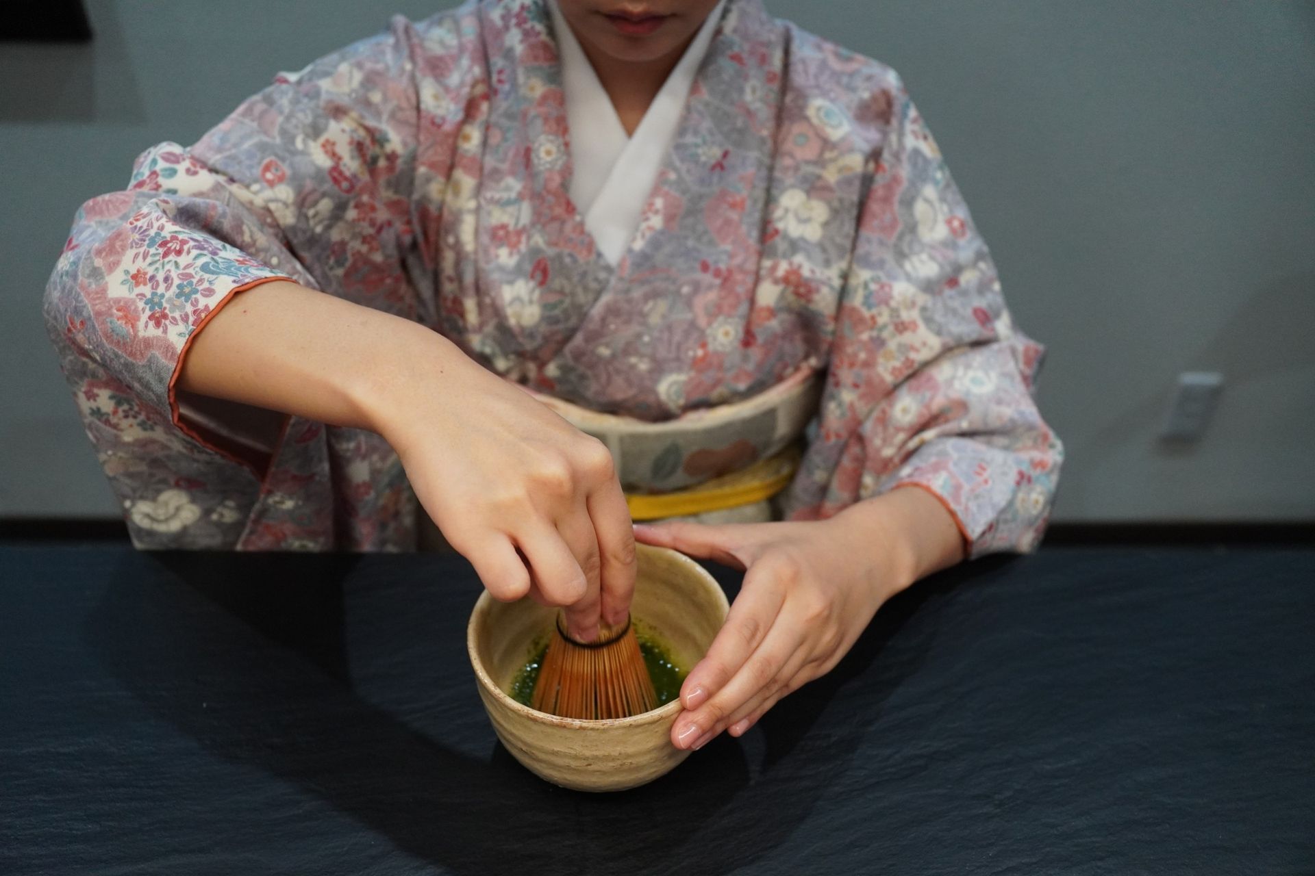 Two guests whisking matcha together