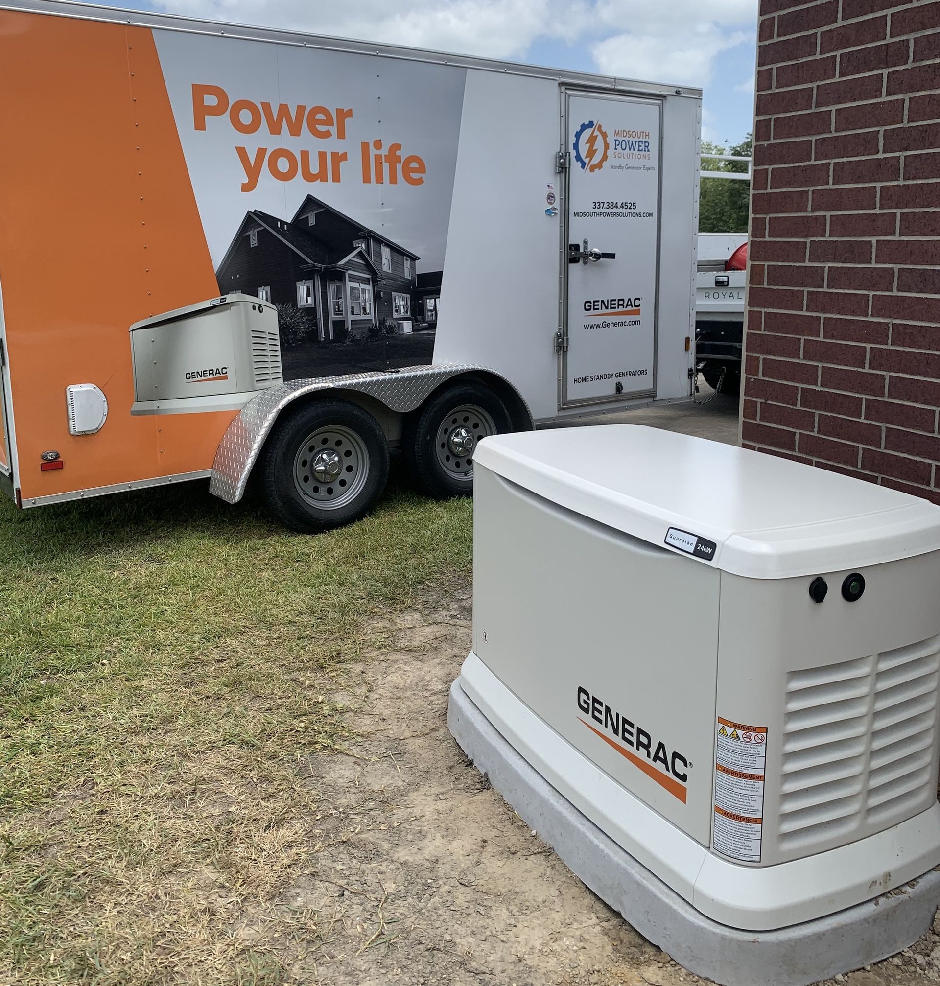 Trailer-mounted generator beside a brick building, with “Power your life” branding on the trailer.