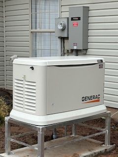 White GENERAC home standby generator on a metal stand beside a house