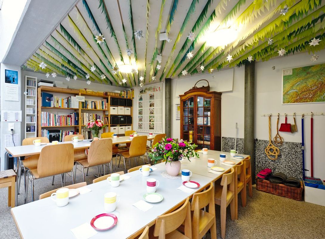 A room with tables and chairs and a green ceiling