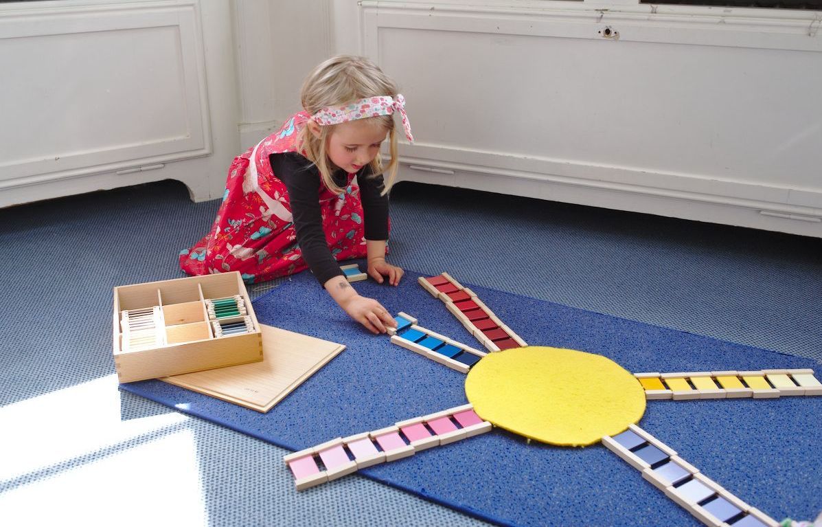 A little girl is playing with a sun made out of wooden blocks