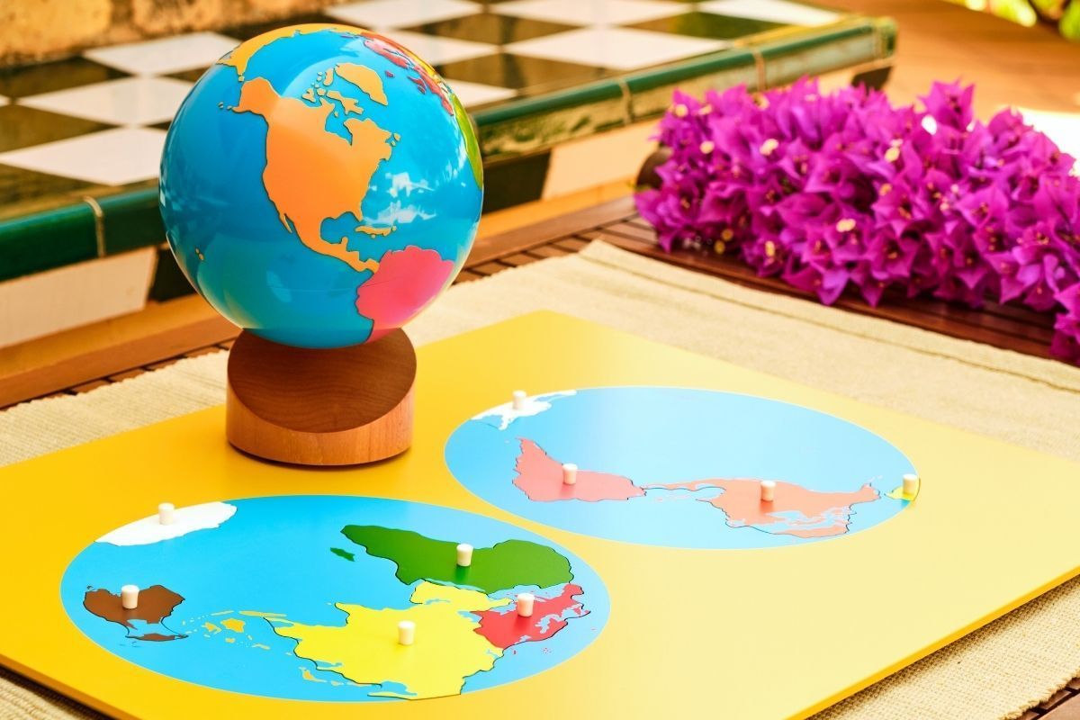 A globe is sitting on top of a yellow board with maps on it.