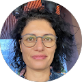 A woman wearing glasses is smiling in a circle.