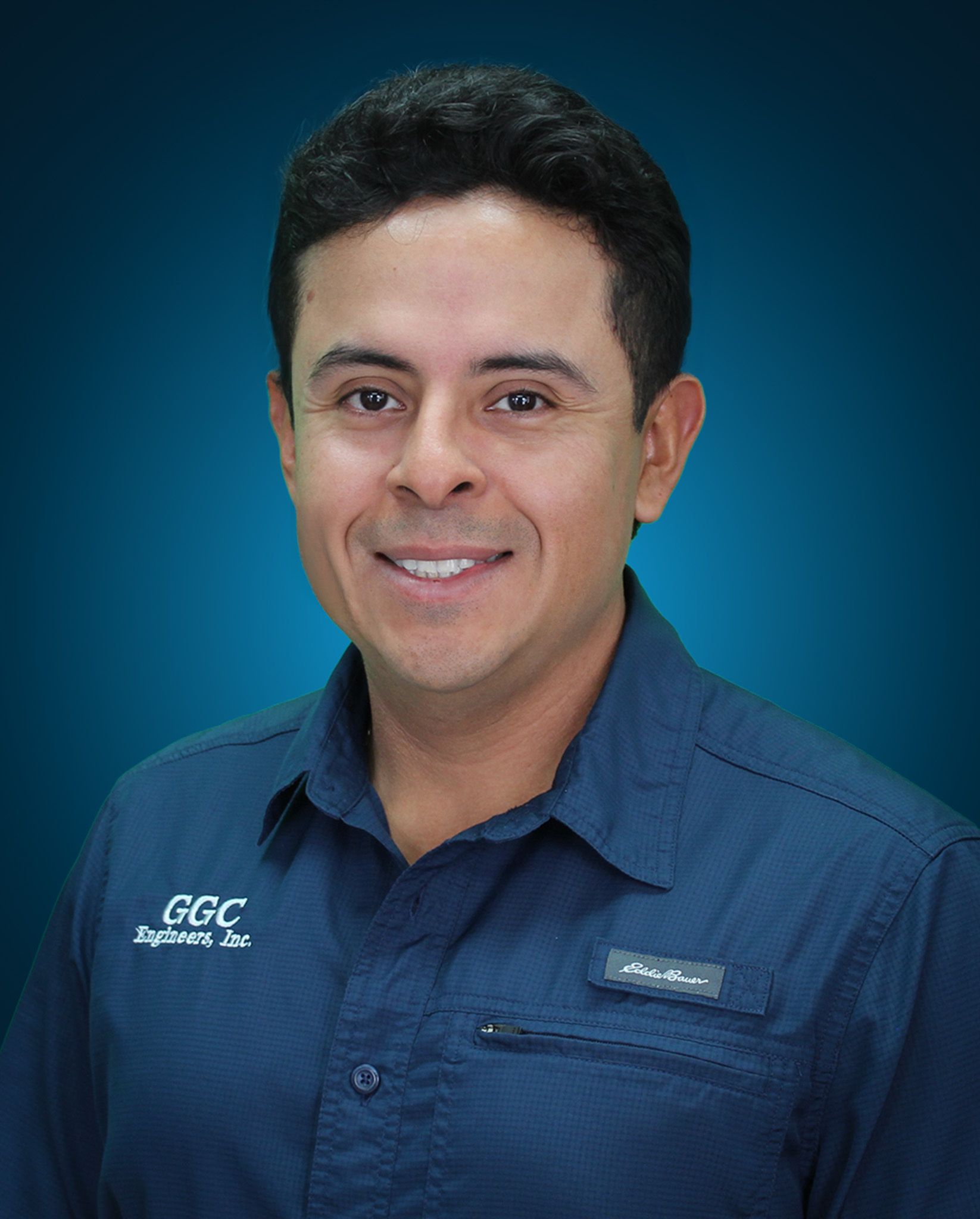 Man in blue shirt smiling, with logo 