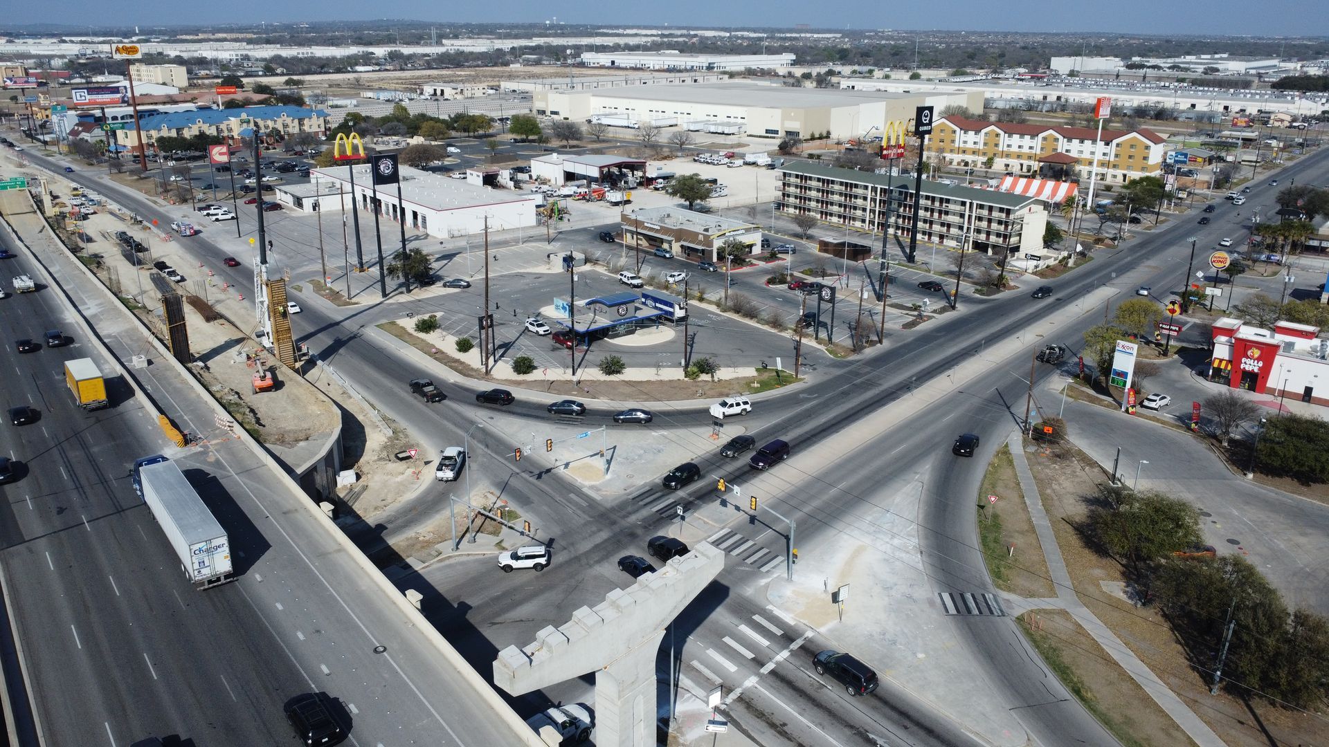 Aerial view of a highway interchange and commercial buildings.