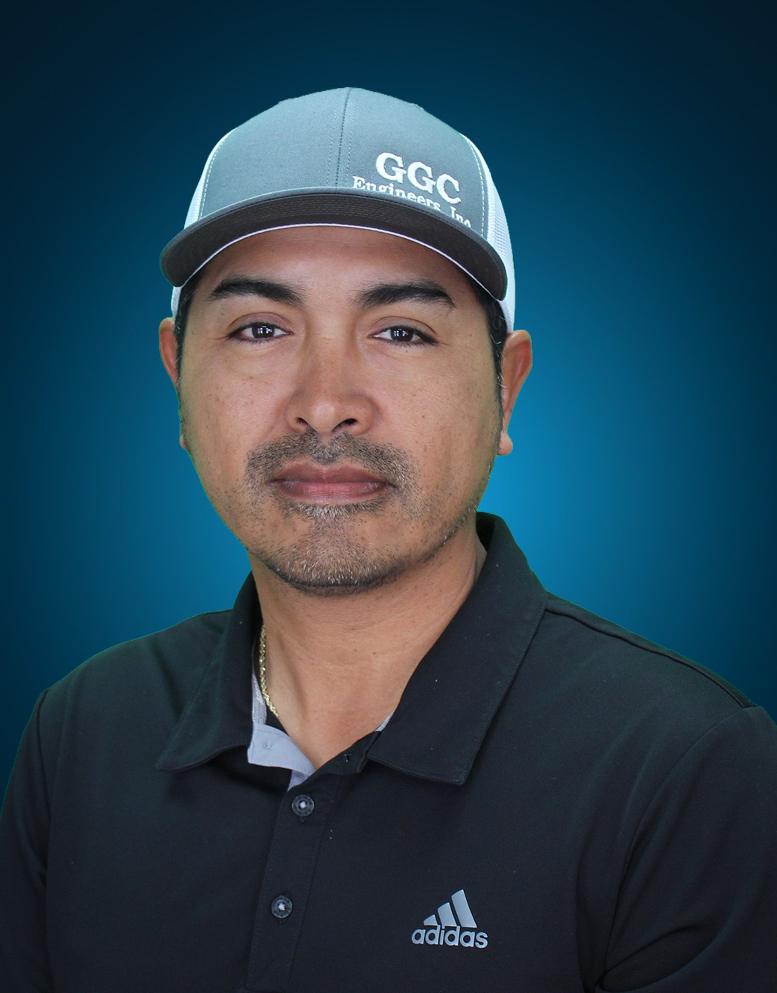 Man in a golf hat and black polo shirt, against a blue background.