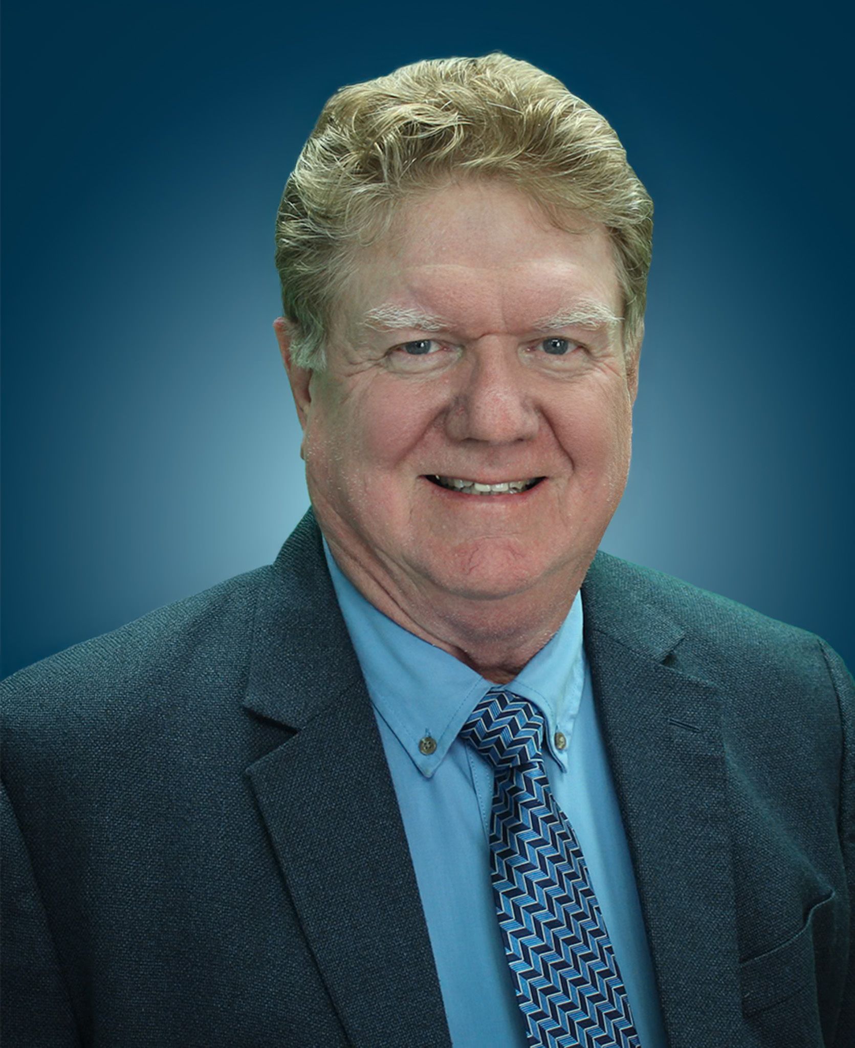 Headshot of Paul Davis against a blue gradient background.