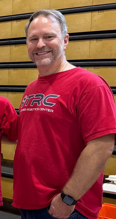 Folded red T-shirt with a large TRC logo and white text printed across the front.