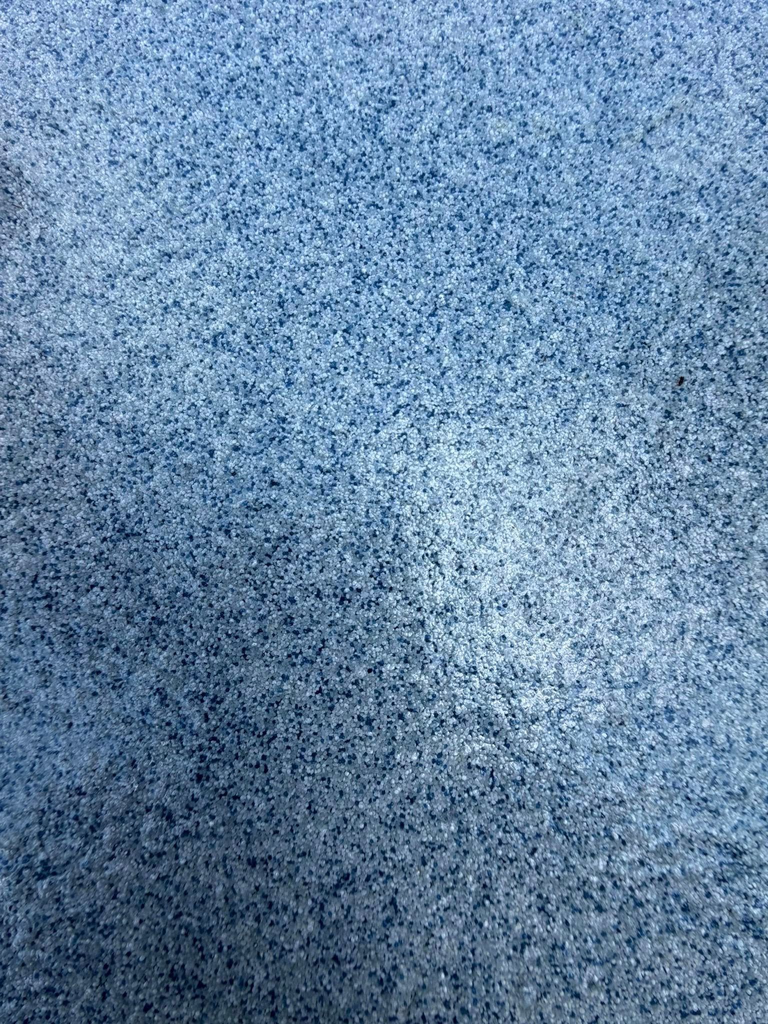 Blue and white speckled abstract texture with a faint diagonal shadow