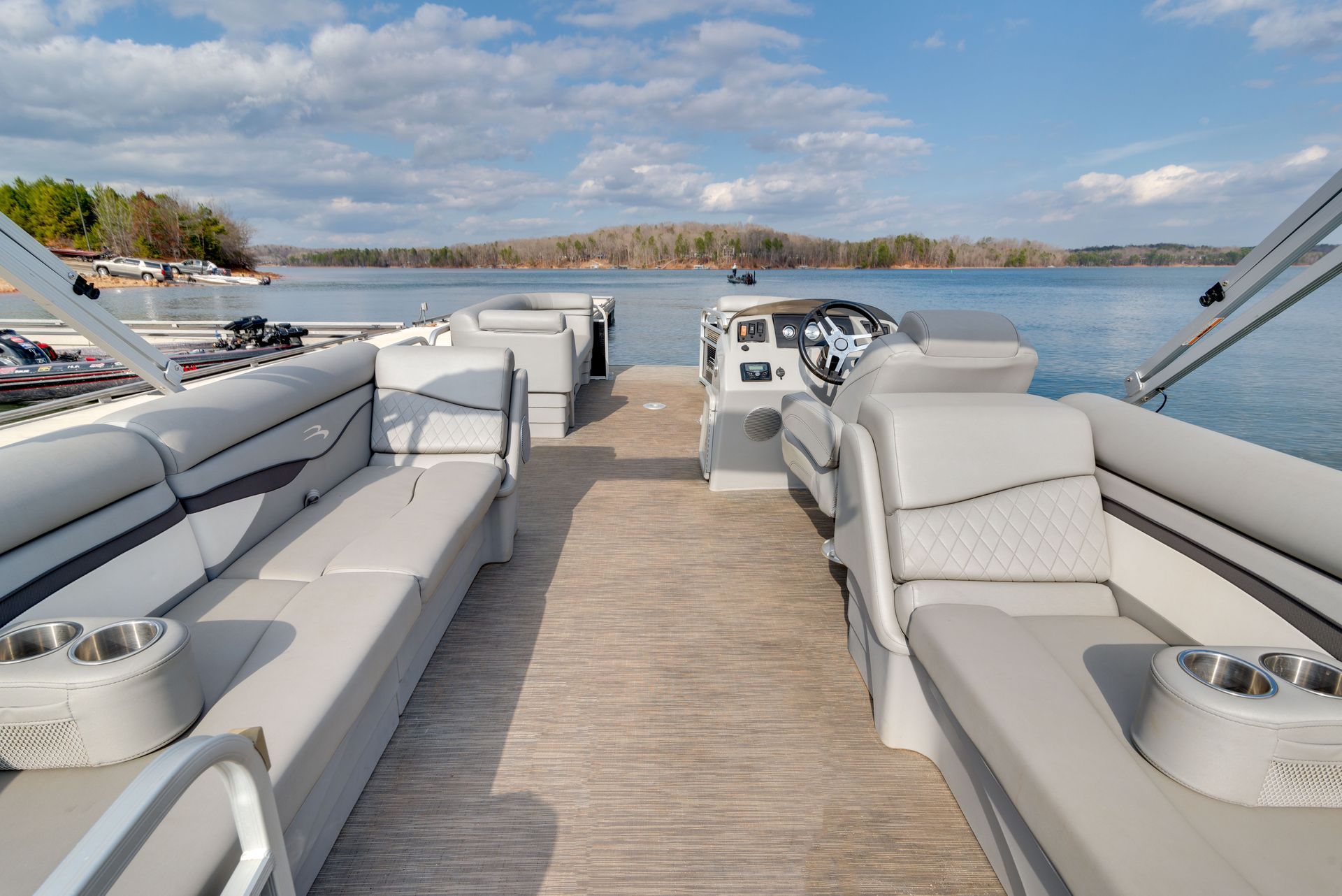 A pontoon boat is docked at a dock on a lake.