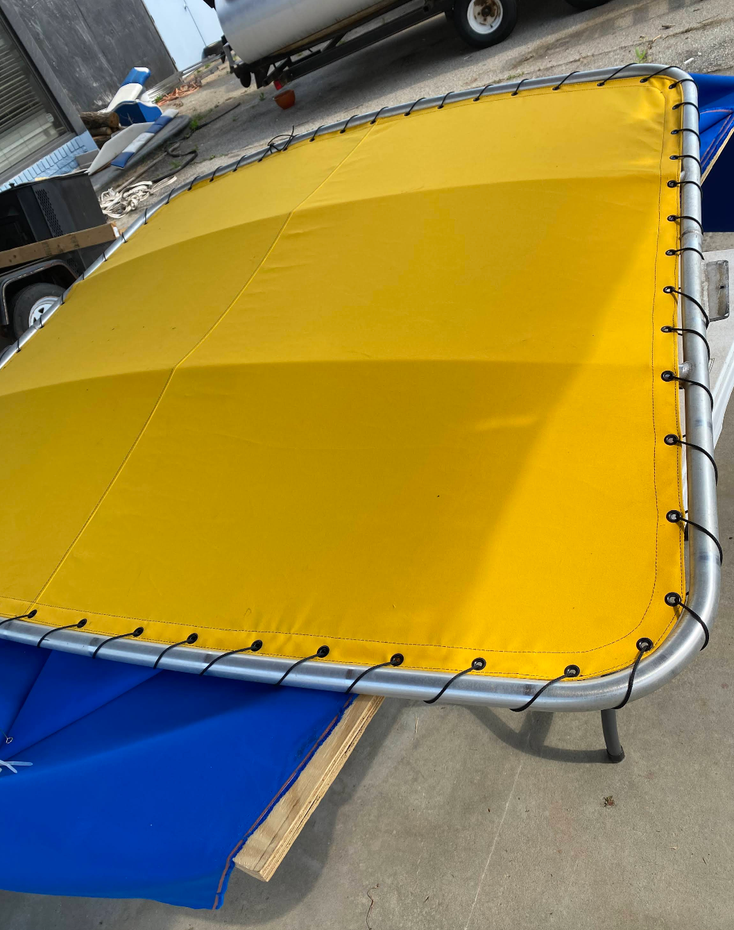 A yellow tarp is sitting on top of a blue tarp.