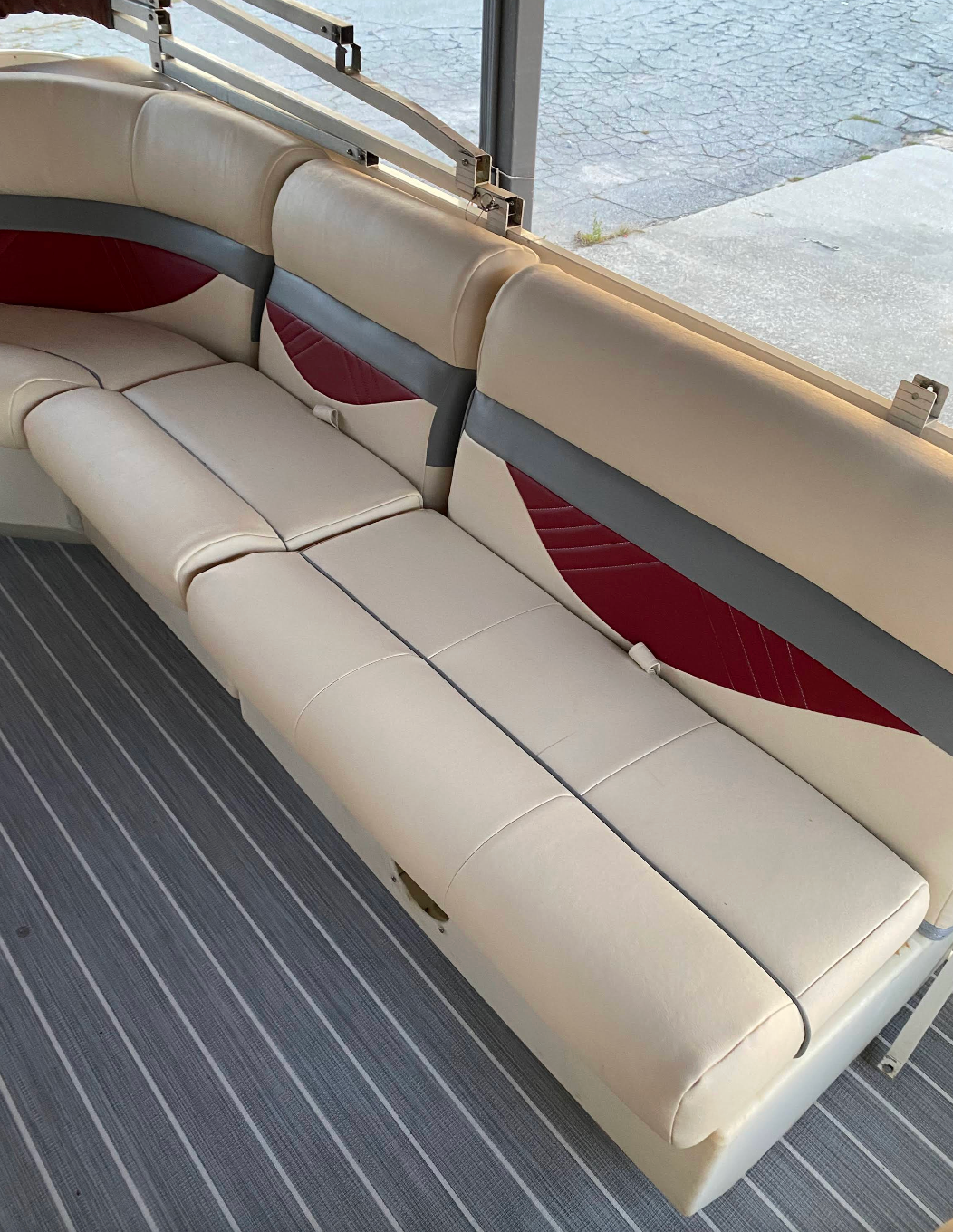 A white and red couch on a pontoon boat.