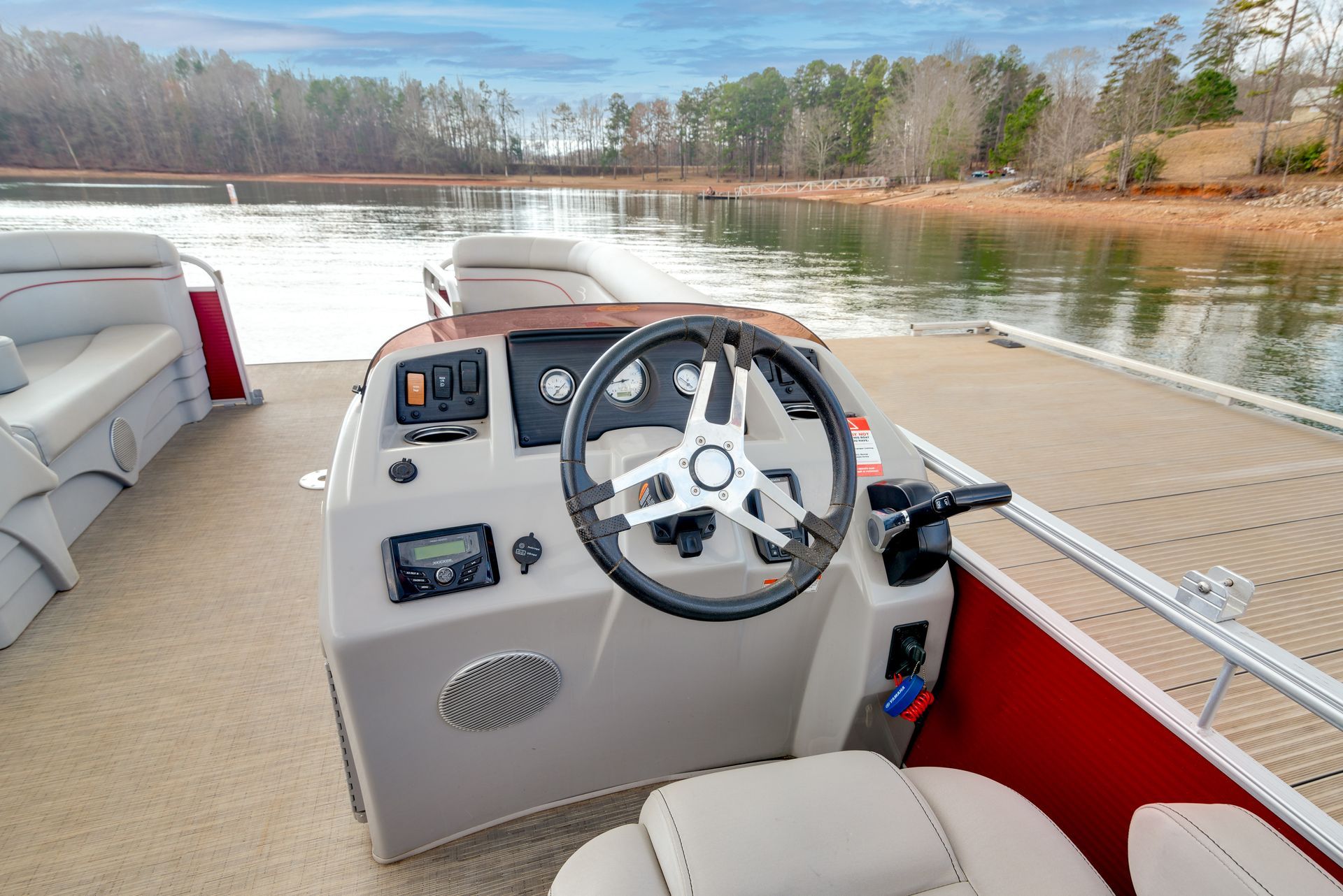 A pontoon boat is docked at a dock on a lake.