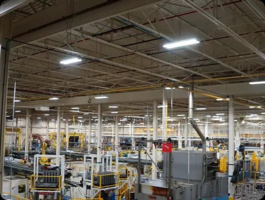 Factory interior with overhead lighting and machinery on the production floor.