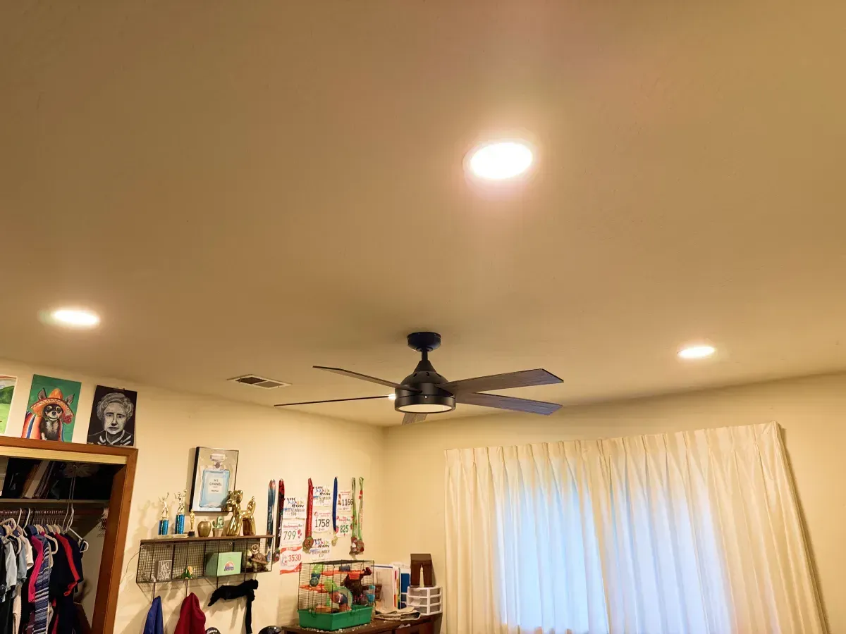 Ceiling with recessed lights, ceiling fan, closet, and a window with white curtains.