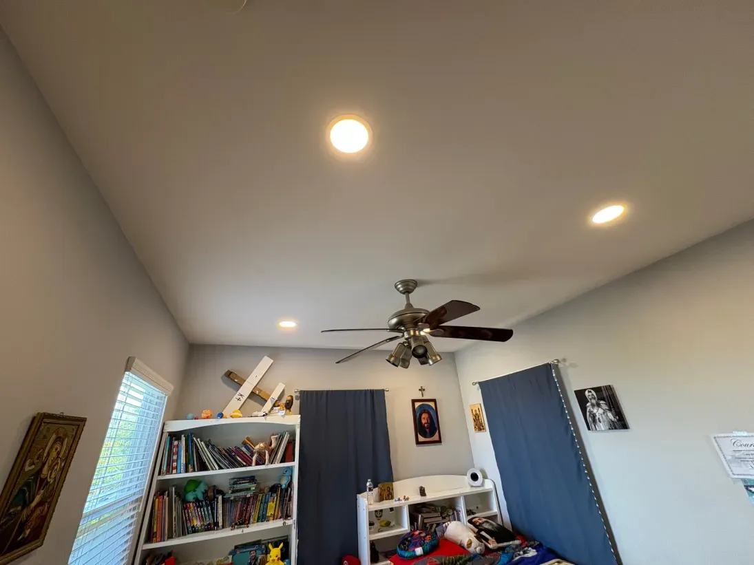 Bedroom ceiling with recessed lights, ceiling fan, and bookshelves.