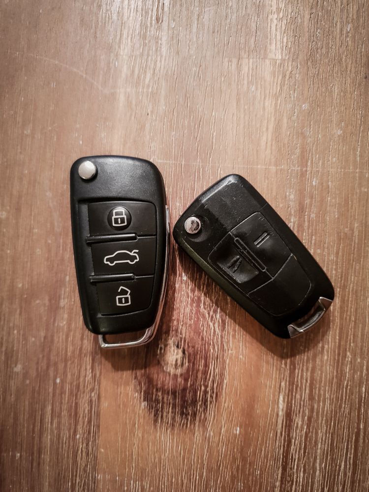 Two Car Keys Are Sitting On A Wooden Table — Port Macquarie Locksmiths In Thrumster, NSW