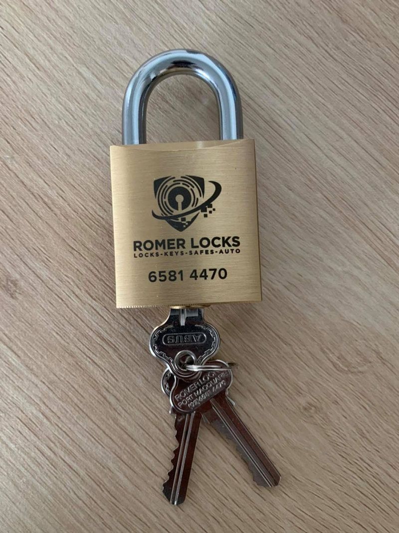 A Padlock With Keys Attached To It Is Sitting On A Wooden Table — Port Macquarie Locksmiths In Port Macquarie, NSW