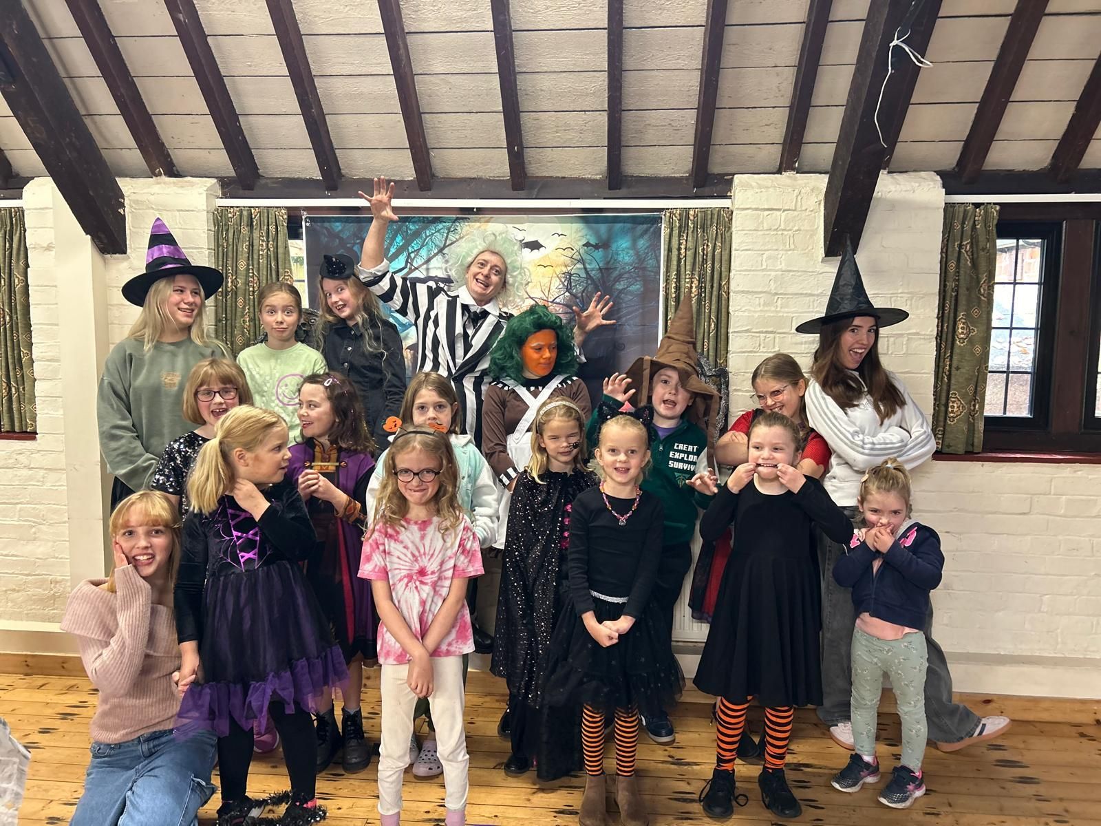 A group of children dressed in halloween costumes are posing for a picture at Dragonfly-craft parties